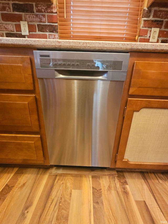 interior details with stainless steel dishwasher and light wood-type flooring