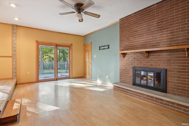 unfurnished living room featuring light hardwood / wood-style floors, ornamental molding, ceiling fan, and a brick fireplace