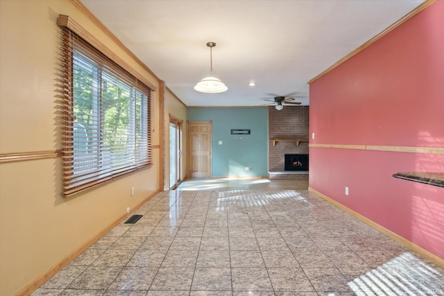 interior space with crown molding, a fireplace, and ceiling fan