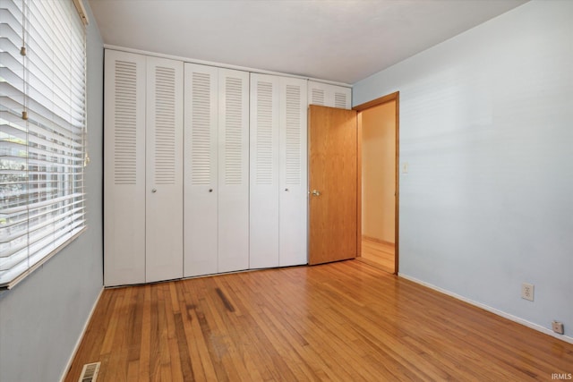 unfurnished bedroom featuring a closet and light wood-type flooring