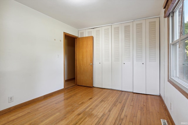 unfurnished bedroom featuring a closet and light wood-type flooring