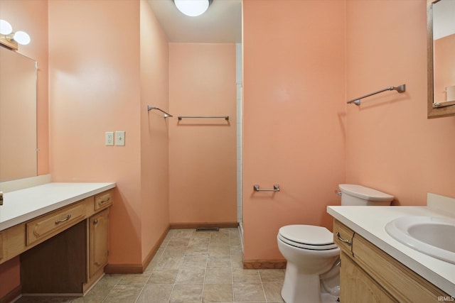 bathroom featuring toilet, vanity, and a shower