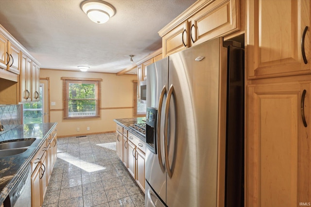 kitchen featuring light brown cabinets, a textured ceiling, stainless steel appliances, and sink