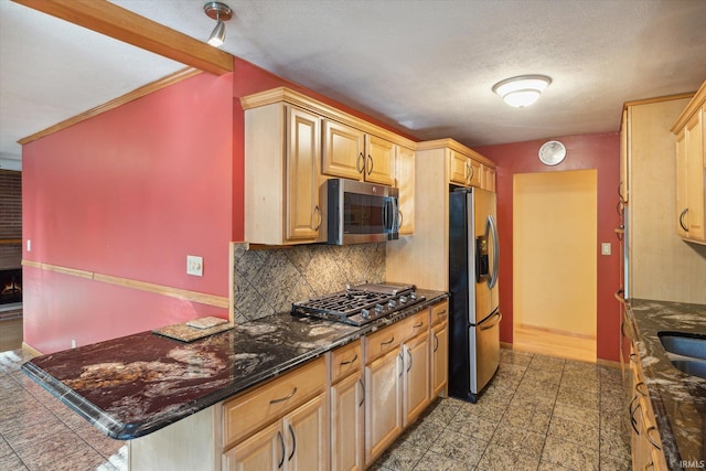 kitchen featuring appliances with stainless steel finishes, light brown cabinets, decorative backsplash, and a textured ceiling