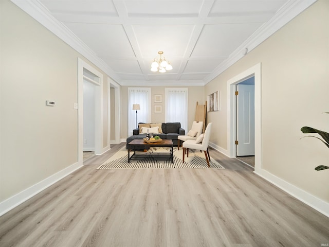 living area with light hardwood / wood-style floors, a notable chandelier, ornamental molding, and coffered ceiling