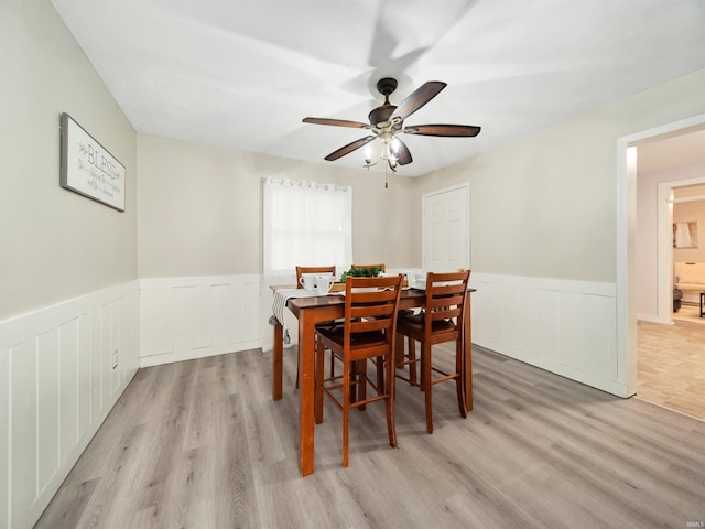 dining area with light hardwood / wood-style floors and ceiling fan