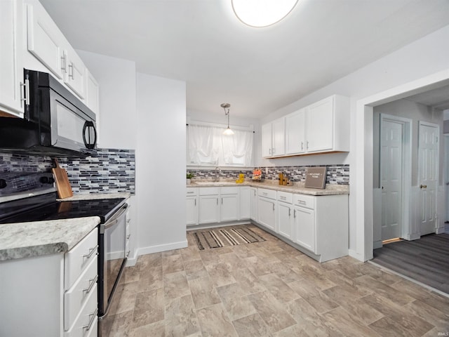 kitchen with tasteful backsplash, sink, electric stove, pendant lighting, and white cabinets