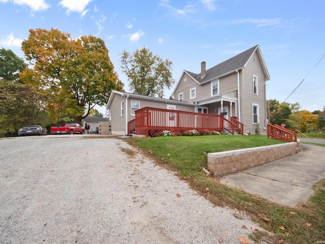 view of side of property featuring a deck and a yard