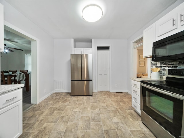 kitchen featuring white cabinetry, light stone counters, and appliances with stainless steel finishes