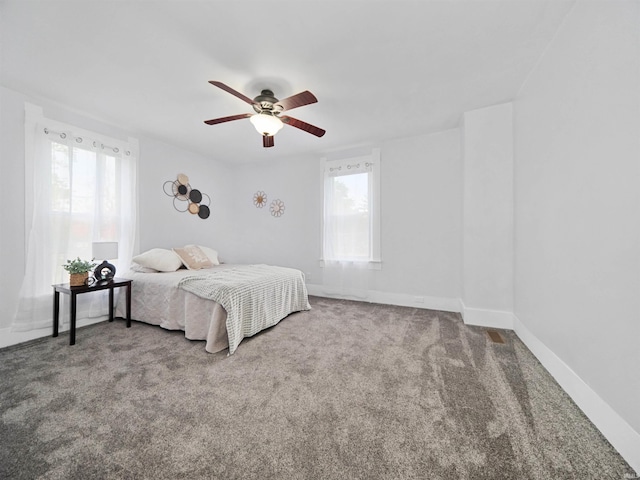 bedroom featuring multiple windows, carpet flooring, and ceiling fan