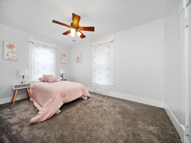 carpeted bedroom featuring multiple windows and ceiling fan