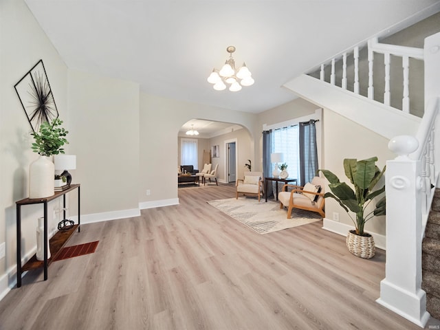 foyer with light hardwood / wood-style flooring and a chandelier