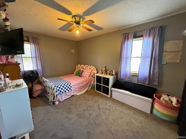 carpeted bedroom with ceiling fan and a textured ceiling