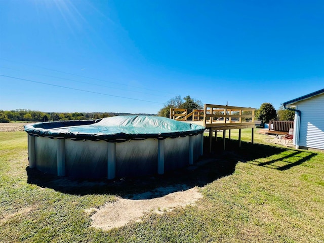 view of pool featuring a deck and a lawn