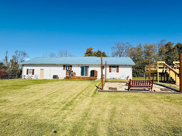 rear view of property with a wooden deck, a yard, and central AC unit