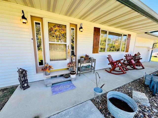 view of patio featuring a garage and a porch