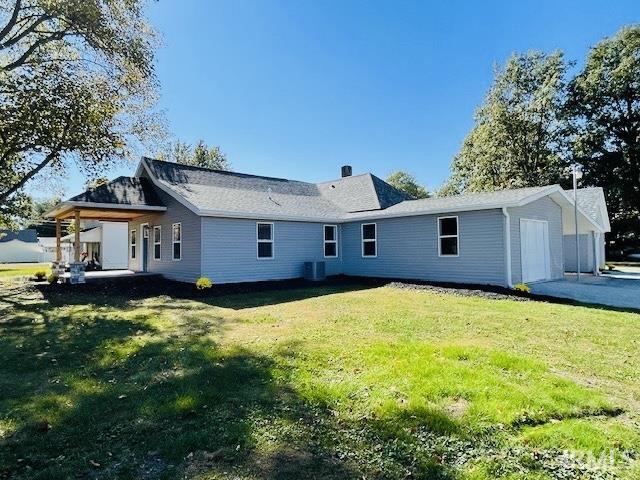 back of property with a lawn and central AC unit