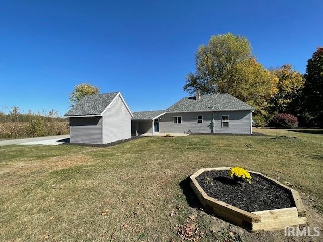 back of house featuring an outbuilding and a yard