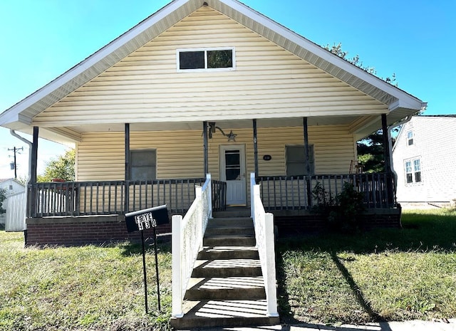 bungalow with a front yard and covered porch