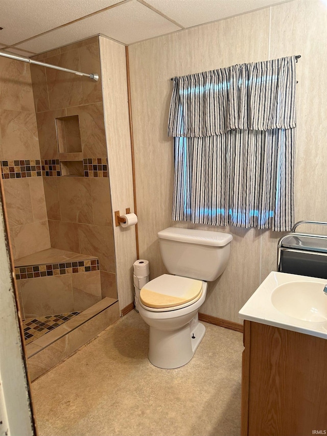 bathroom featuring vanity, toilet, and a tile shower