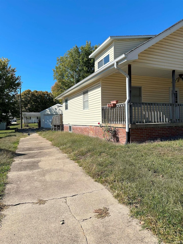 view of home's exterior featuring covered porch and a lawn