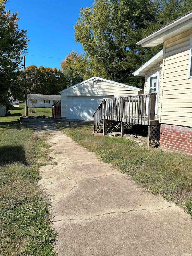 view of side of property featuring a yard, a deck, an outbuilding, and a garage