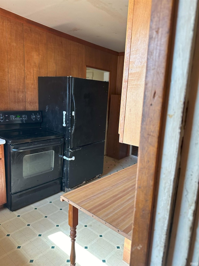 kitchen featuring black appliances and wooden walls