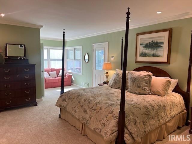 bedroom featuring crown molding, multiple windows, and light colored carpet