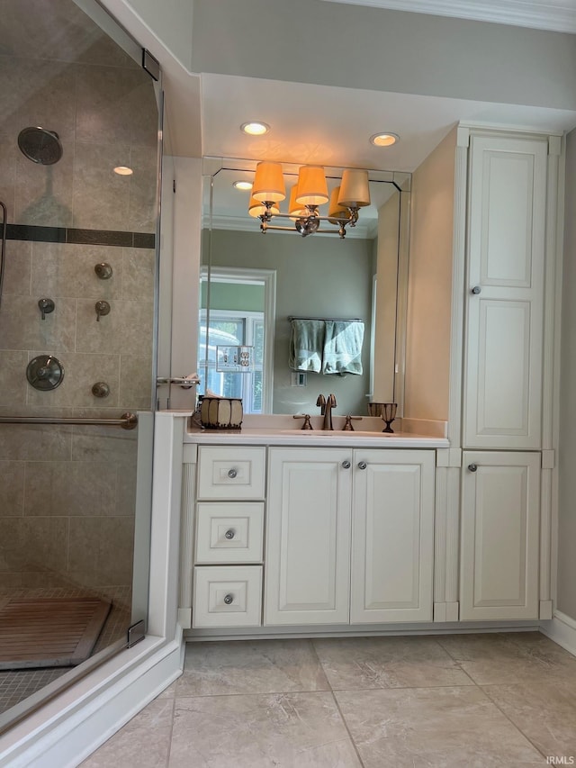 bathroom featuring vanity, a notable chandelier, ornamental molding, and a shower with door