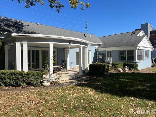 back of house featuring a patio area and a lawn