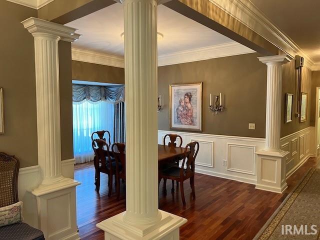 dining area featuring crown molding, decorative columns, and dark hardwood / wood-style flooring