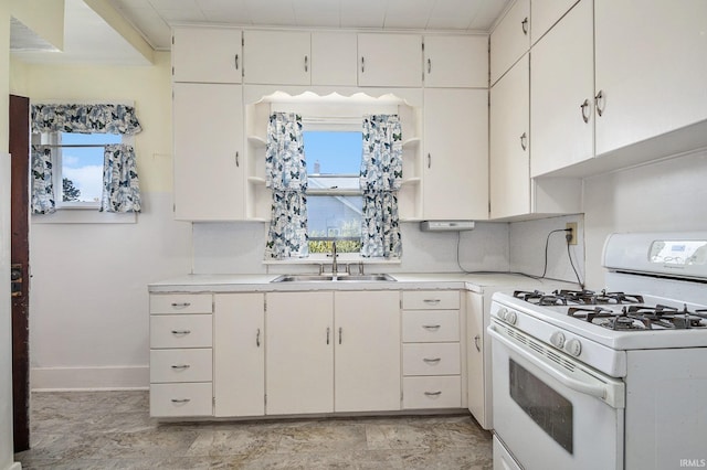 kitchen featuring white cabinetry, white gas range oven, and a healthy amount of sunlight