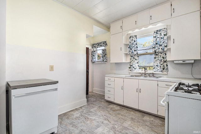 kitchen with white range with gas cooktop, white cabinets, and sink