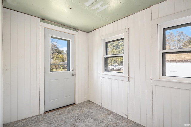 doorway to outside featuring wooden walls