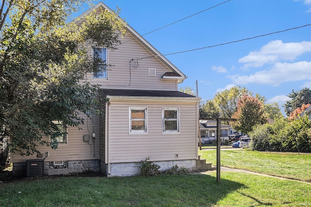 view of side of home with a lawn and central AC unit