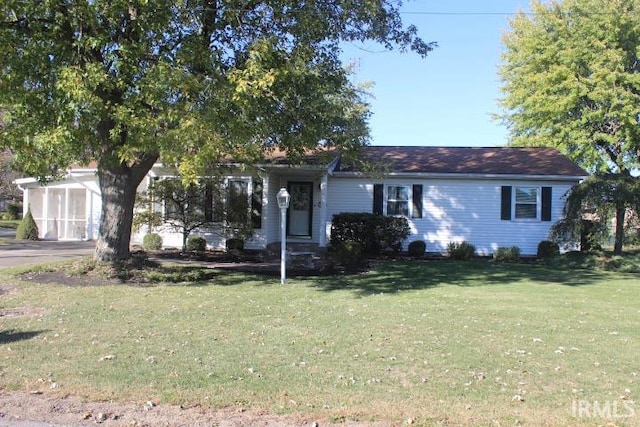 view of front facade with a storage unit and a front lawn