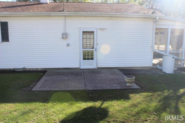 back of house featuring a yard, a patio area, and a sunroom