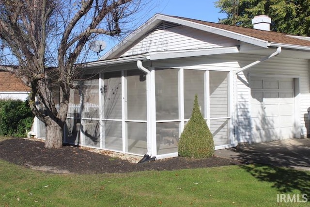 view of side of home featuring a sunroom and a garage