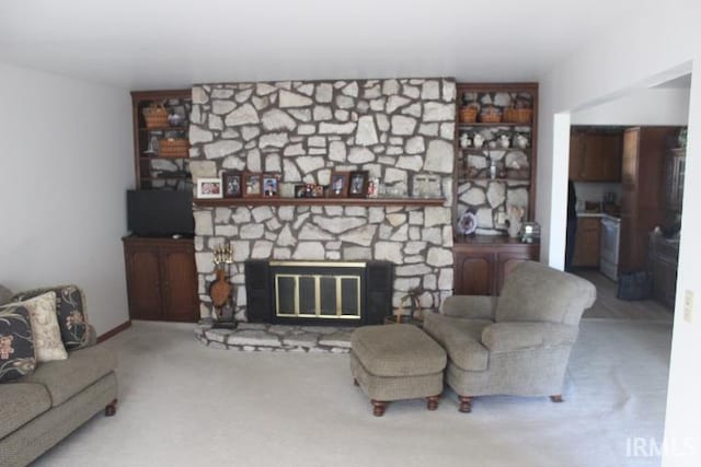 carpeted living room with a stone fireplace