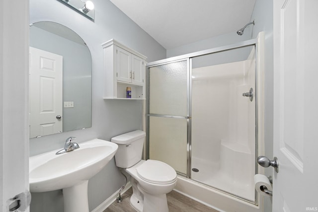 bathroom featuring toilet, hardwood / wood-style flooring, sink, and an enclosed shower