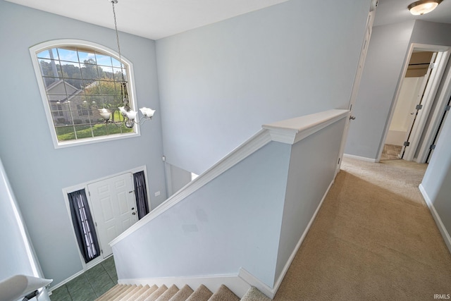 carpeted entrance foyer with an inviting chandelier