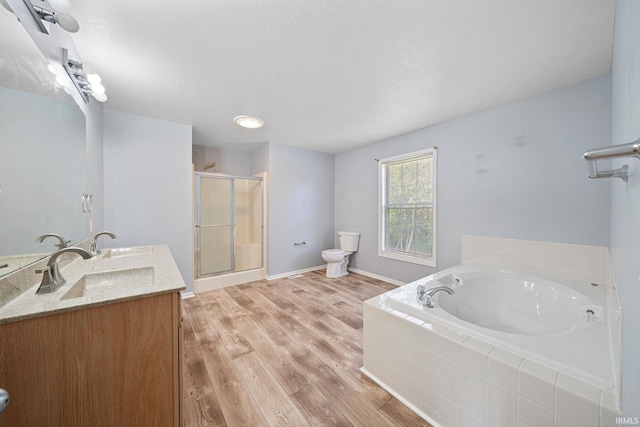 full bathroom with toilet, hardwood / wood-style flooring, plus walk in shower, and vanity