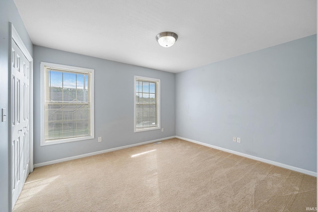 empty room with light carpet and a healthy amount of sunlight