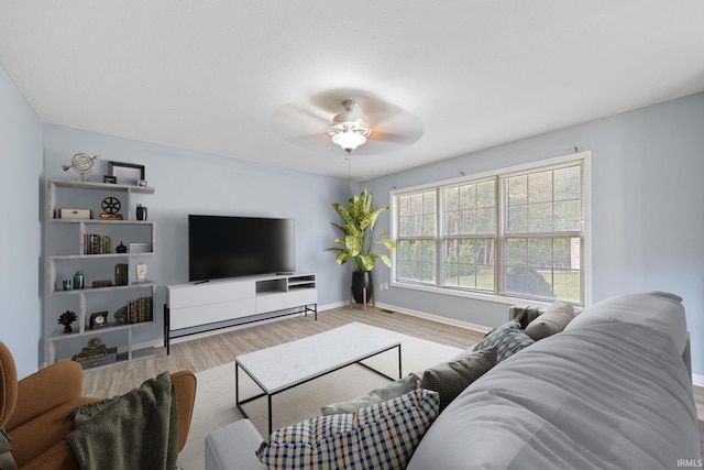 living room with light wood-type flooring and ceiling fan