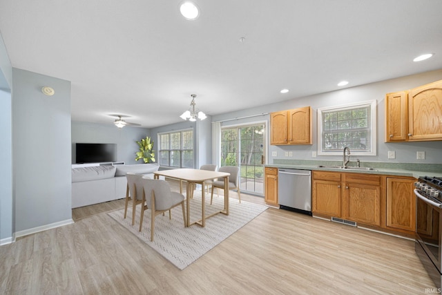 kitchen featuring sink, light wood-type flooring, ceiling fan with notable chandelier, hanging light fixtures, and stainless steel appliances