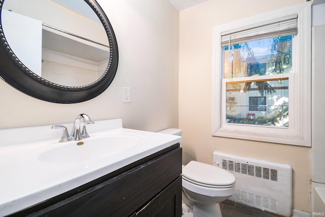 bathroom with vanity, radiator heating unit, and toilet