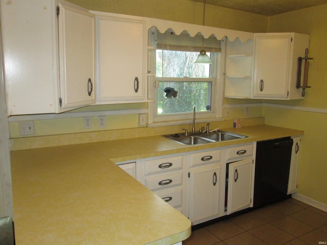 kitchen with dark tile patterned floors, white cabinetry, black dishwasher, hanging light fixtures, and sink