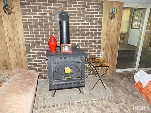 interior details featuring a wood stove and wooden walls