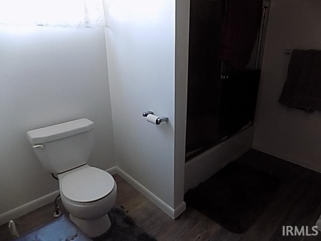 bathroom with toilet, hardwood / wood-style flooring, and walk in shower