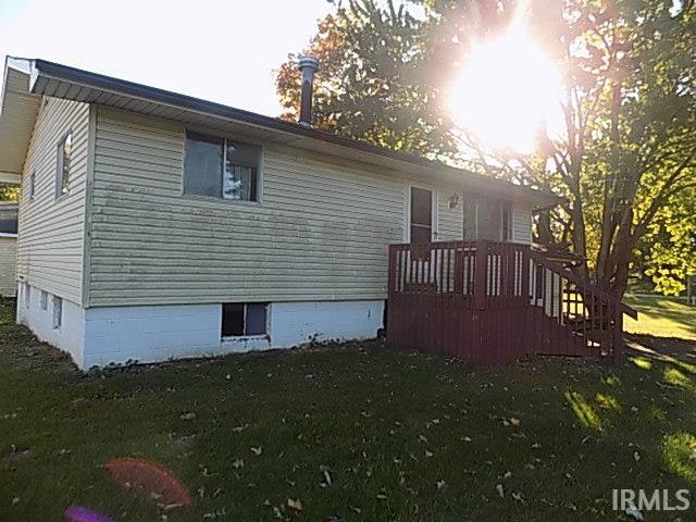 view of side of property with a yard and a deck